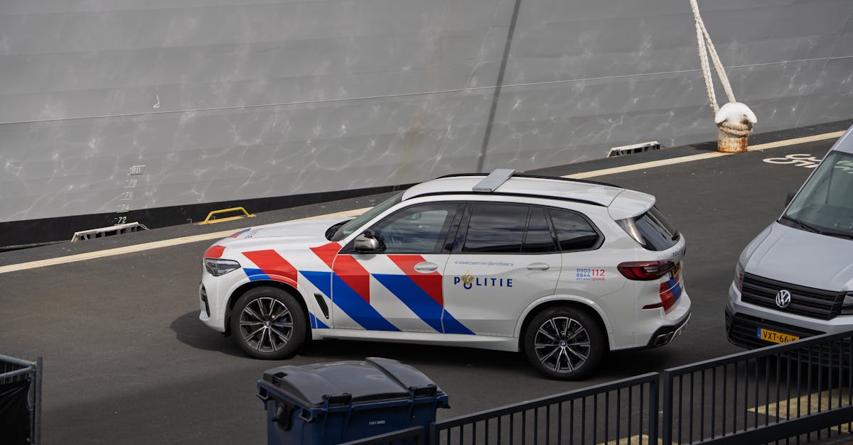 Dutch police vehicle parked near a large ship at a dock, showcasing maritime security presence.