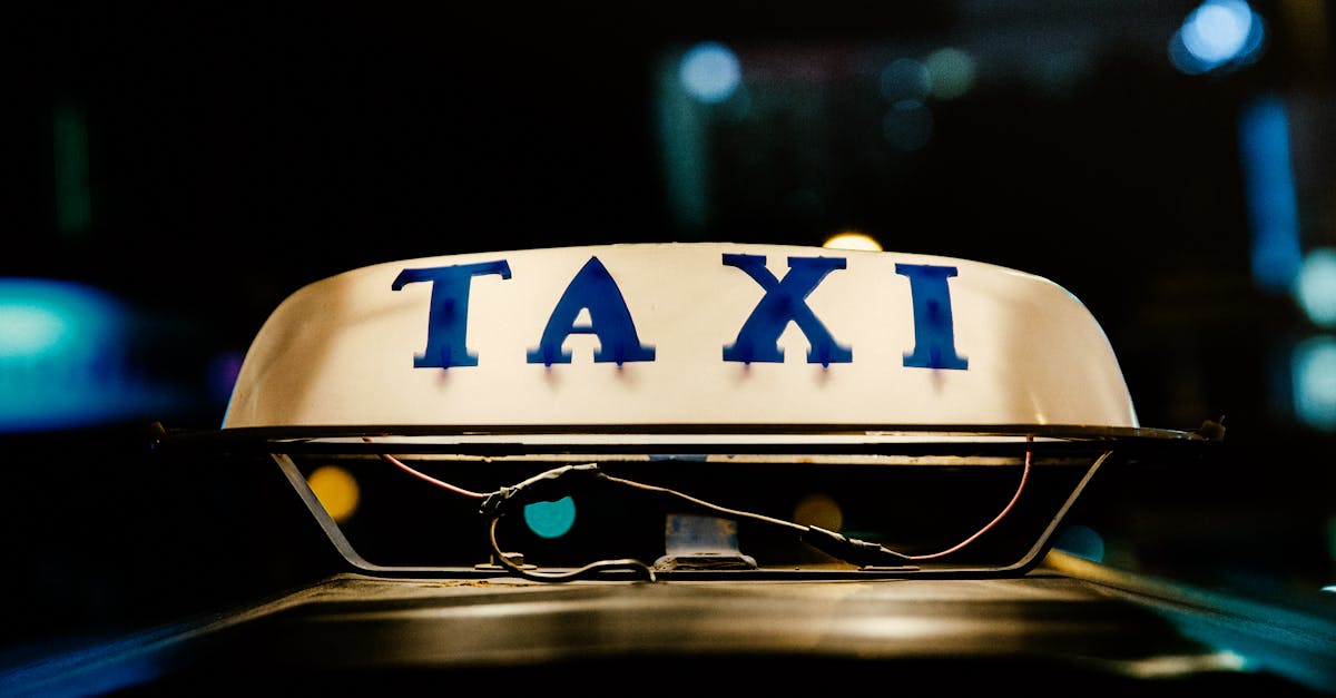 Close-up view of an illuminated taxi sign in a bustling city at night.